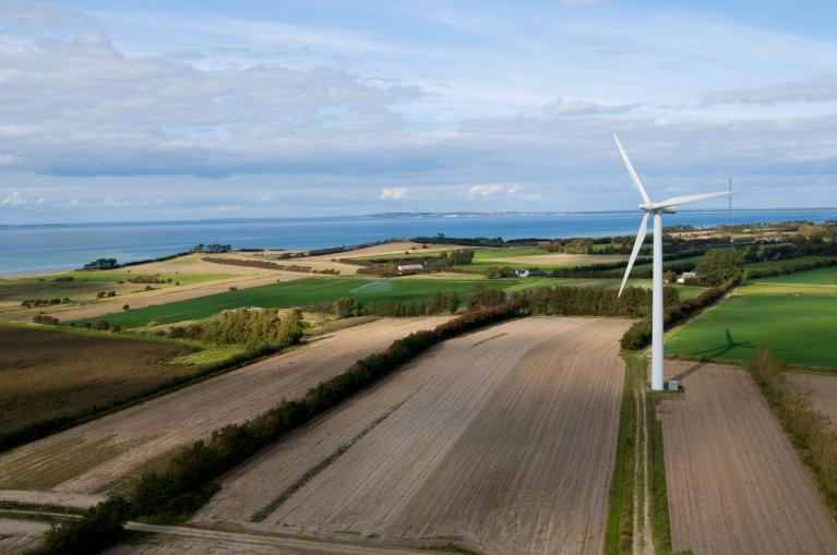 Image aérienne d'un champs et d'une éolienne